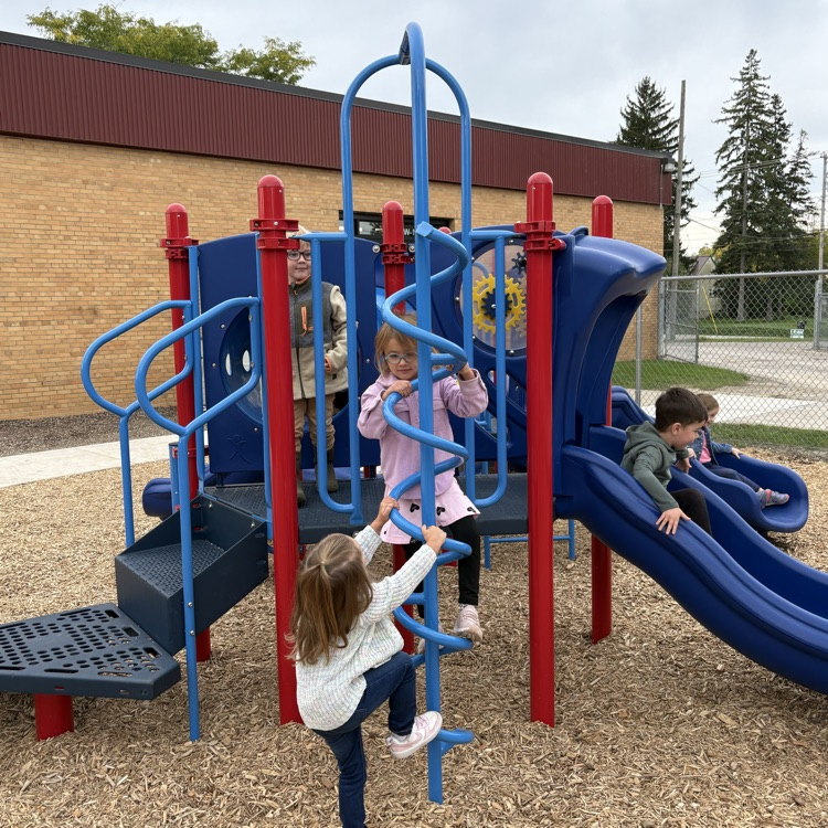 kids playing on a blue and red play structure