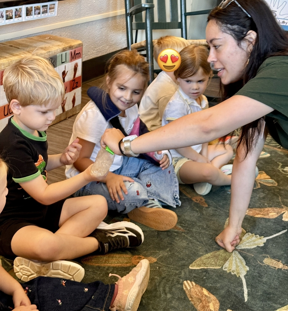 children sitting on a rug looking at a plastic bag