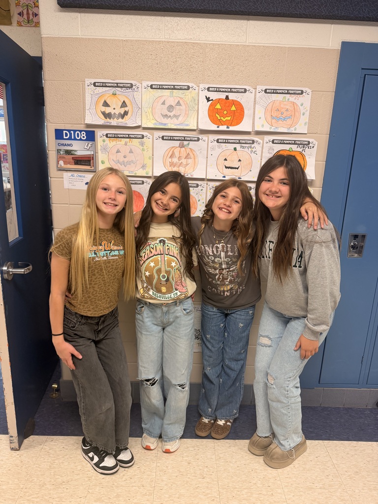 4 girls posing in front of pumpkin drawings