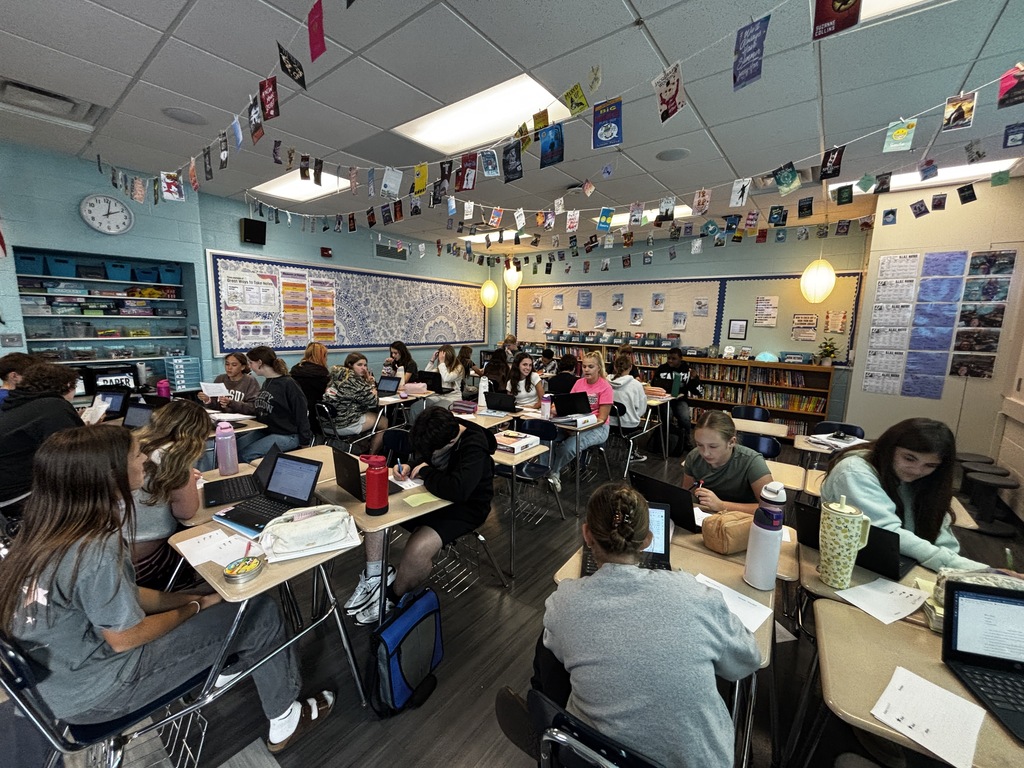 middle school students in a classroom at their desks working on Chromebooks