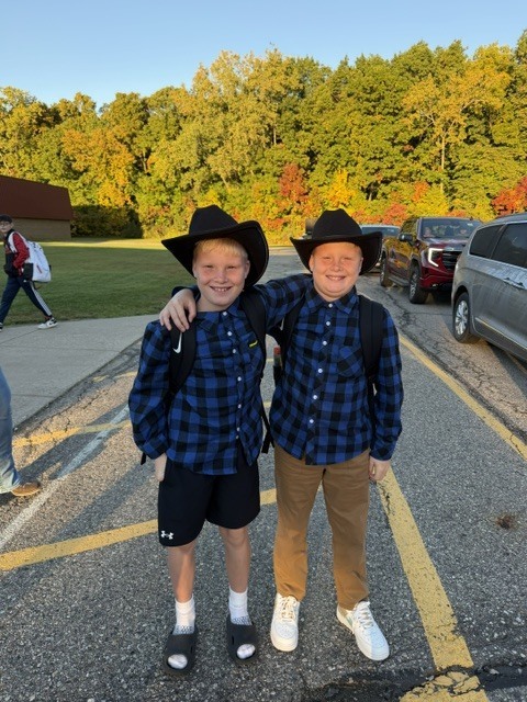 2 boys dressed like cowboys wearing the same outfit