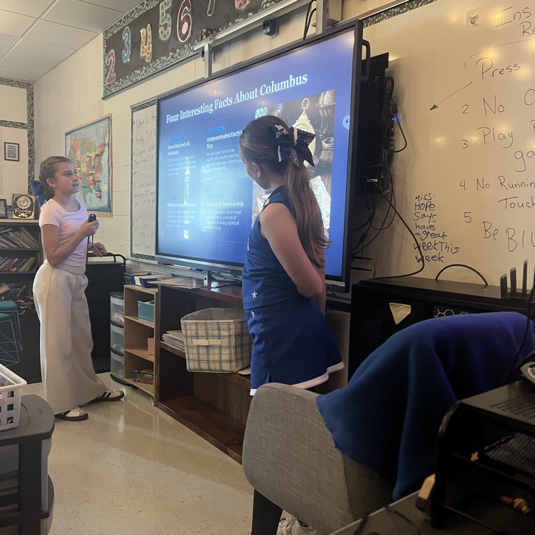 2 girls giving a presentation to a classroom