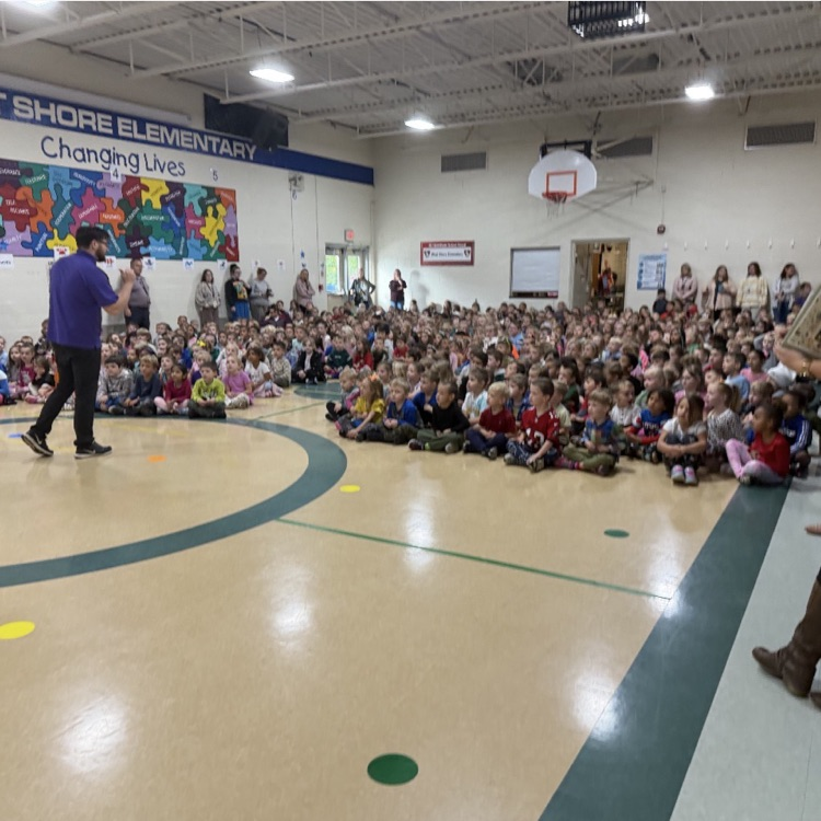 large group of students gathers in a school gym for an assembly