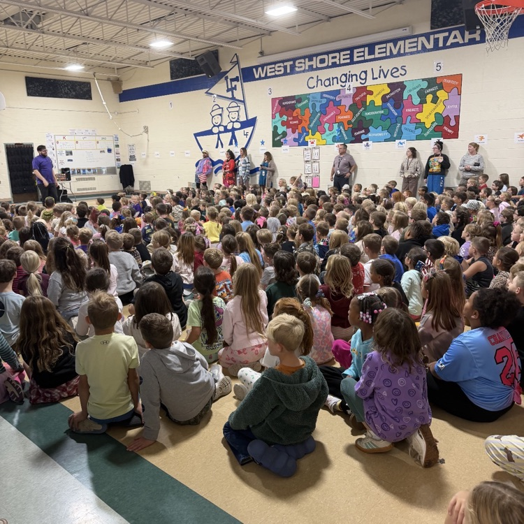 large group of students gathers in a school gym for an assembly