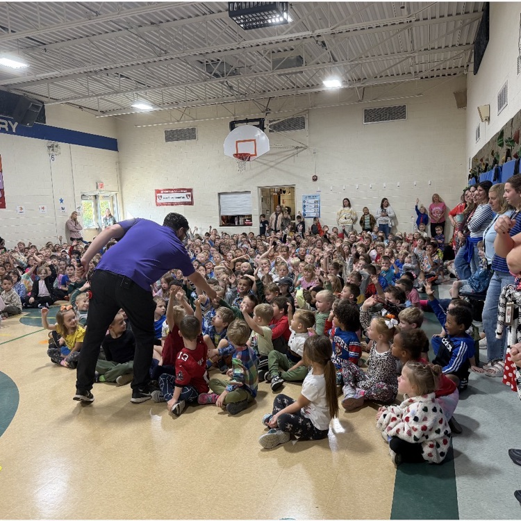 large group of students gathers in a school gym for an assembly