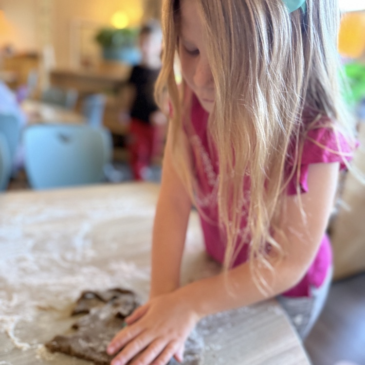 little girl pressing dough 