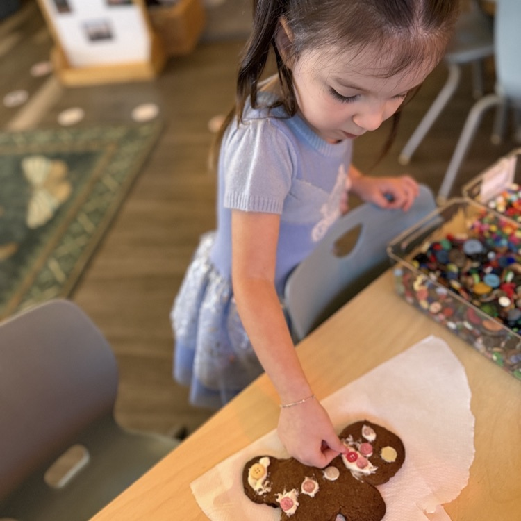 little girl decorating a gingerbread man