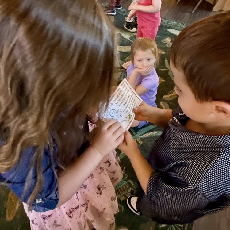 2 students reading a small piece of paper