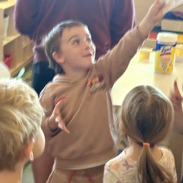little boy smiling and reaching for something