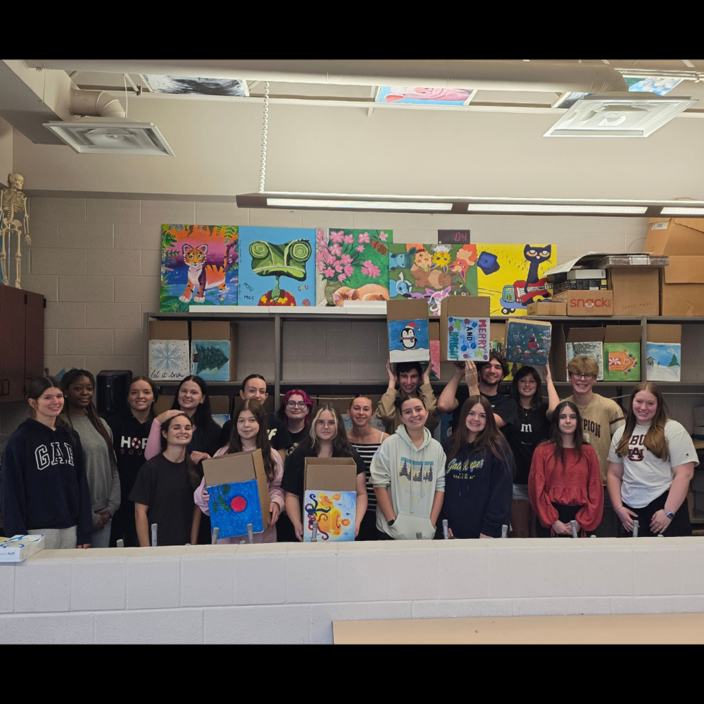 group of students posing together in a high school art room