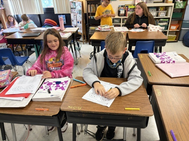 2 students doing homework at their desks