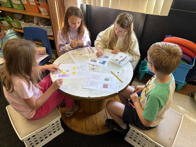 4 students doing homework at a table