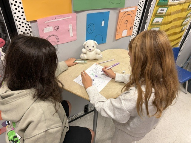 2 students doing scvhoolwork at a table