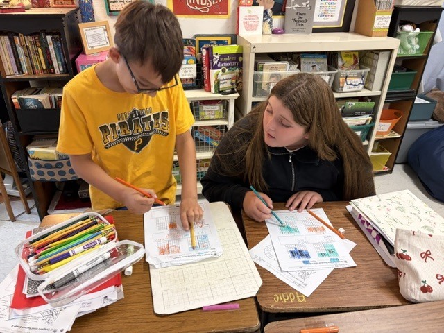 2 students working at a desk together