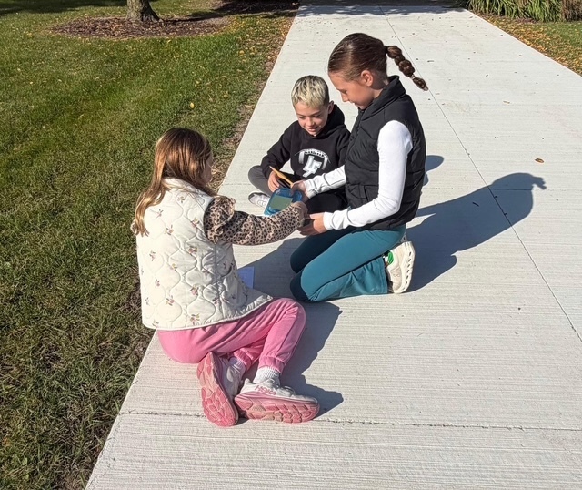 3 kids doing a science experiment outside