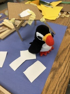 stuffed bird on a blue piece of construction paper