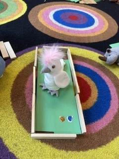 stuffed bird on a green piece of construction paper
