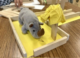 stuffed rhino on a yellow piece of construction paper