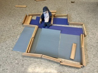 stuffed dolphin on a blue piece of construction paper