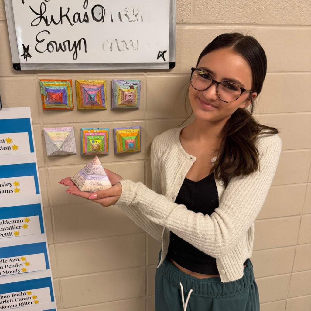 girl holding a paper pyramid