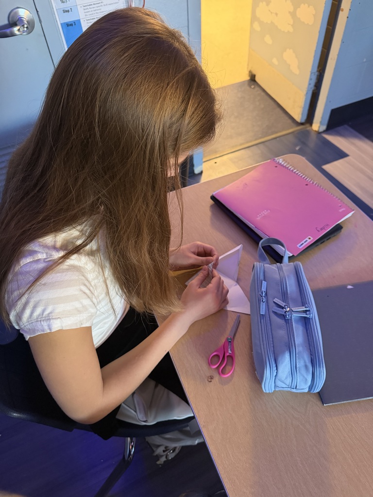 girl making a paper pyramid