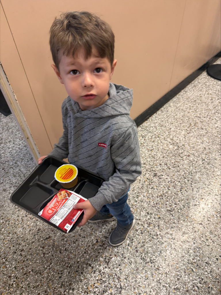 little boy holding a lunch tray