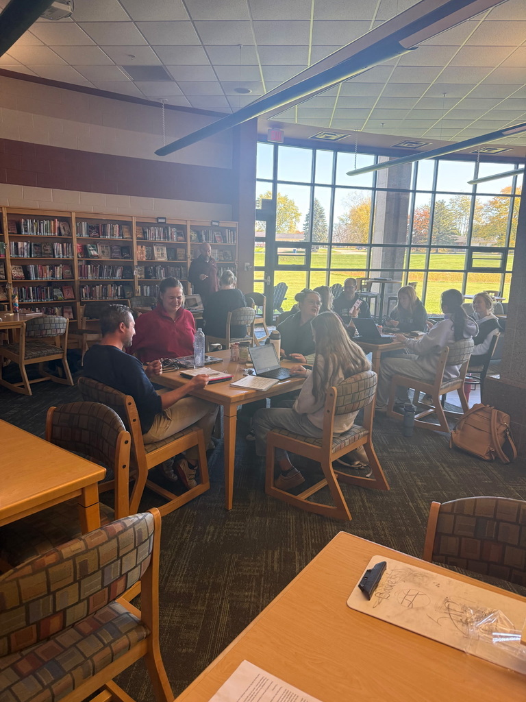 group of adults sitting together at a table in a library