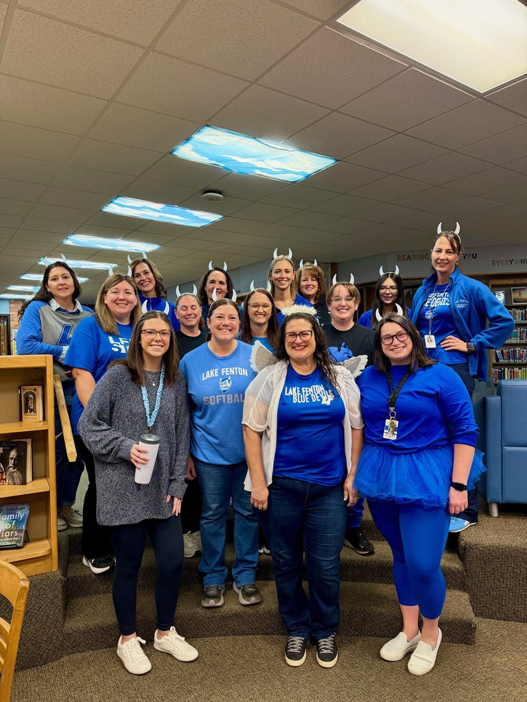 group of women dressed in blue wearing white devil horns