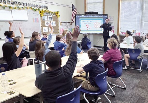 Classroom full of students with hands raised