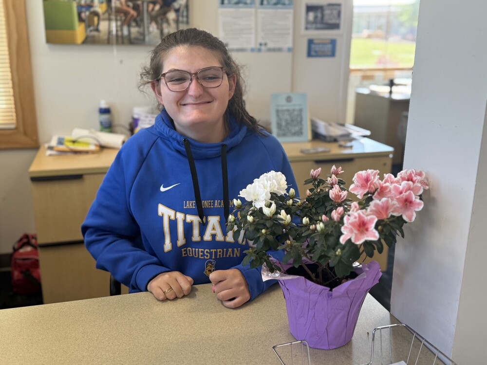 student in HS with Flowers on desk.