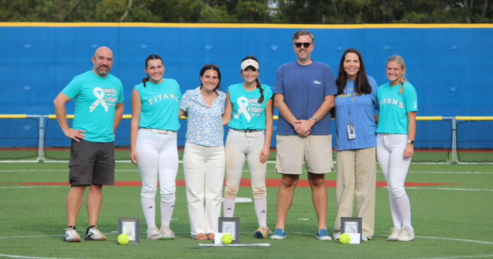 students on the softball field in Teal
