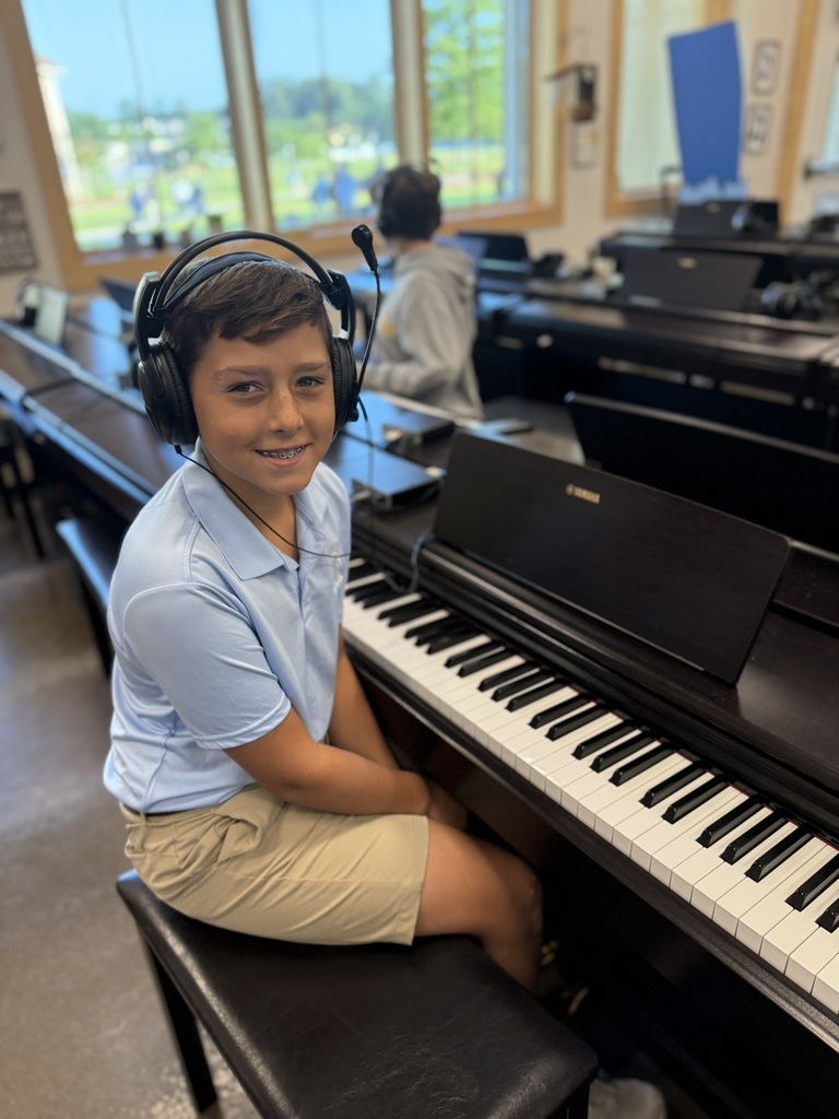 student in piano lab smiling