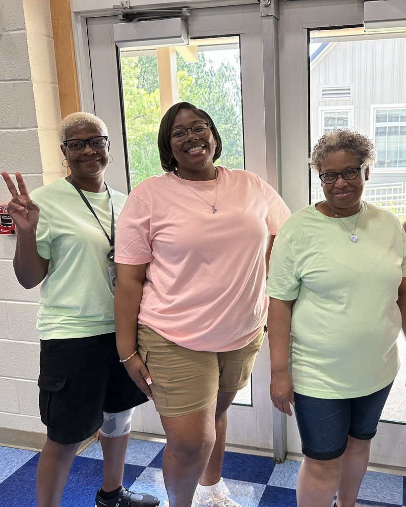three janitorial staff members in pink shirts