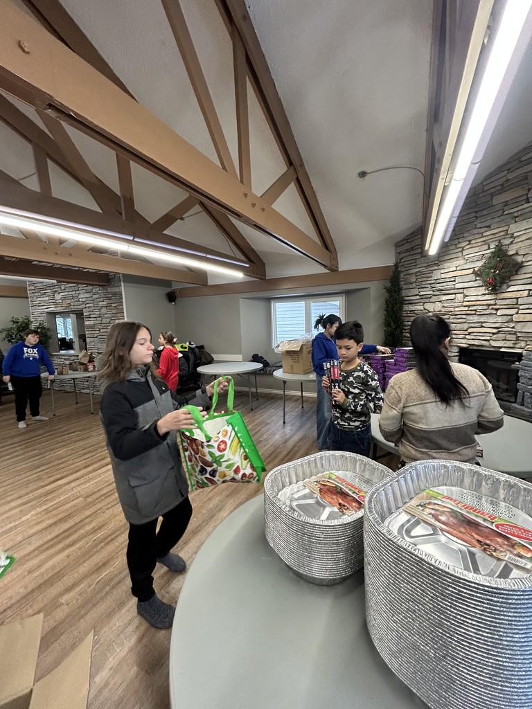 students sitting in front of food hampers