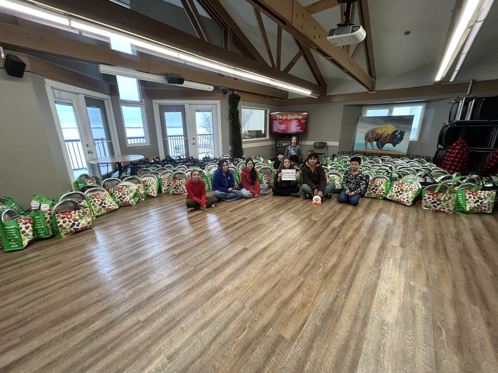 students sitting in front of food hampers