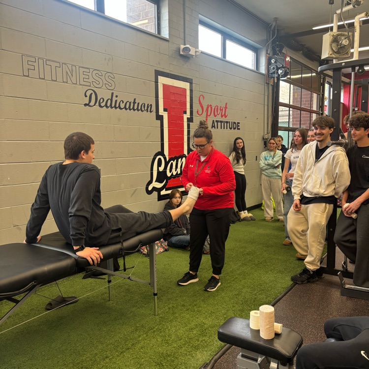 Mr. Cervino's Kinesiology class learning hands on taping methods from our Athletic Trainer Janell
