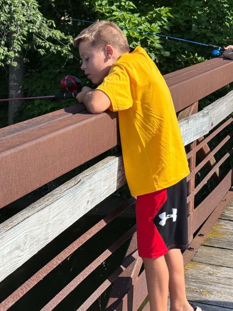 Photo of boy fishing on a bridge