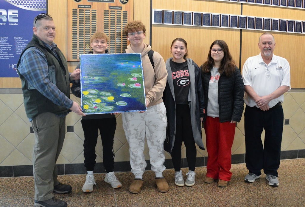 Board Member McArthur and High School Teacher Mr. Miller pictured with High School Art Students 