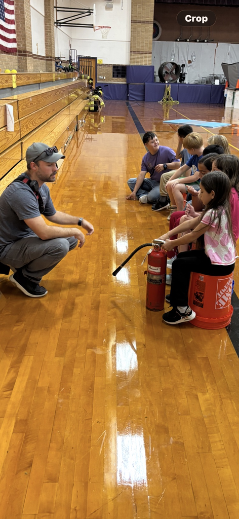 Fireman Taylor Conrady teaching students how to use a fire extinguisher