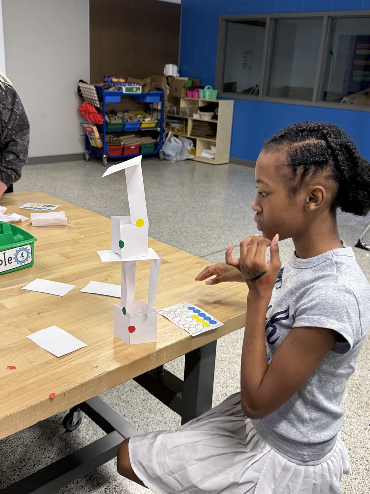 6th Grade Student creating an index card tower
