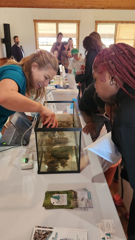 A student is being shown a demonstration by a fish tank at the Marine Career Fair