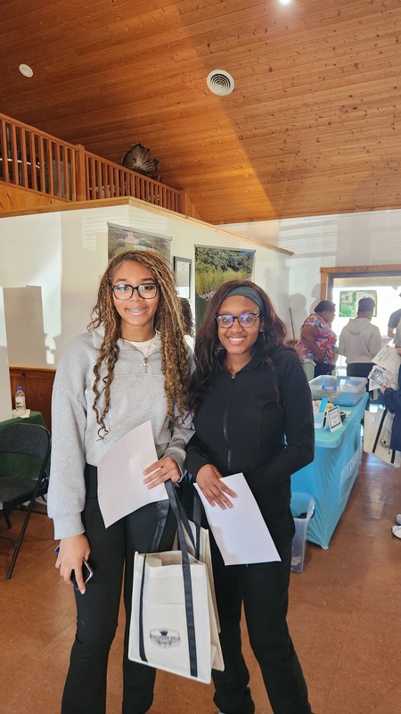 Two students holding merchandise they got from the Marine Career Fair