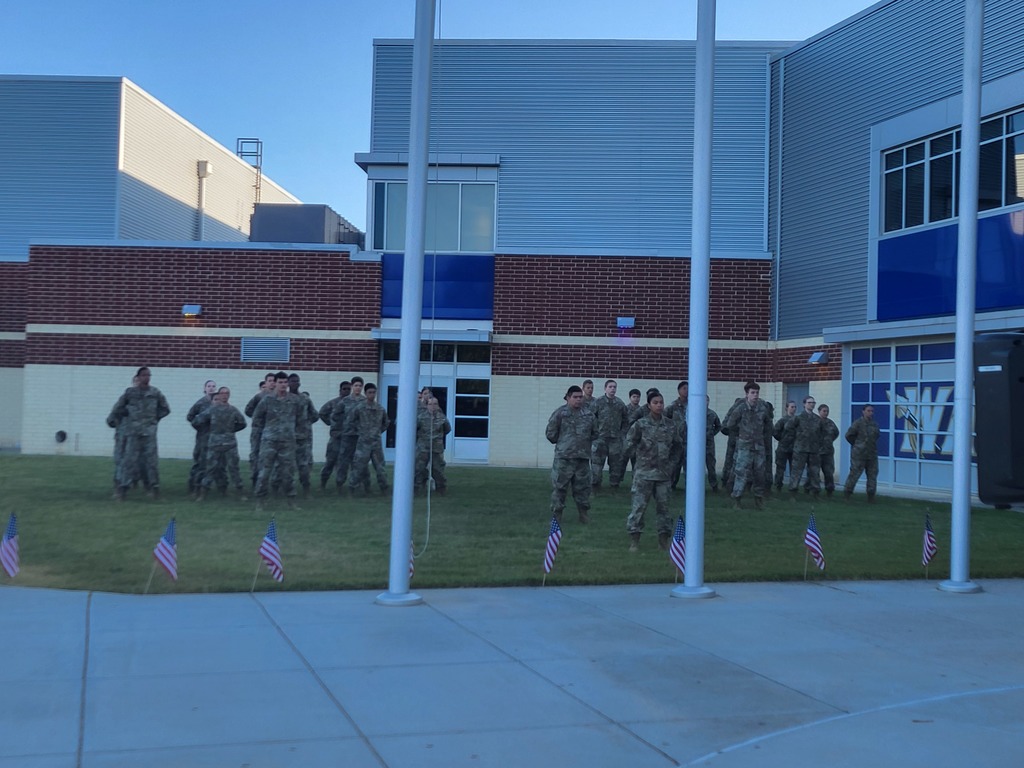 ILHS JROTC battalion stands at attention on lawn in front of school