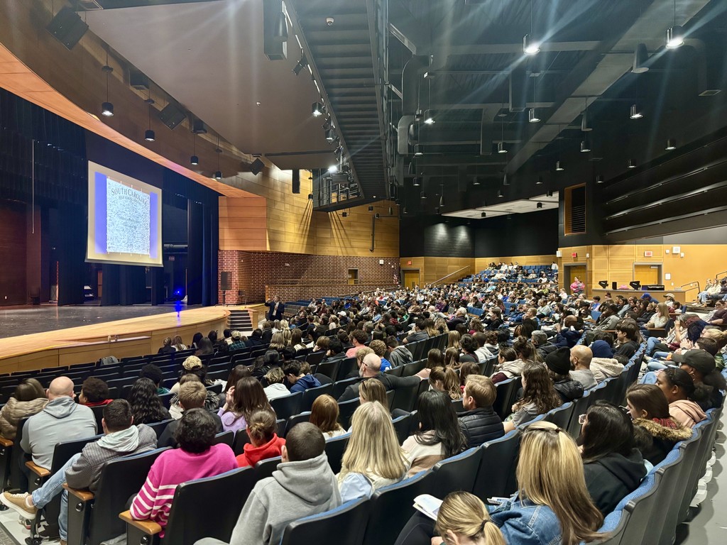 an audtorium full of families watching a presentation