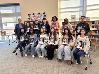 top 20 seniors from ILHS sit in 2 rows holding their Senior portraits