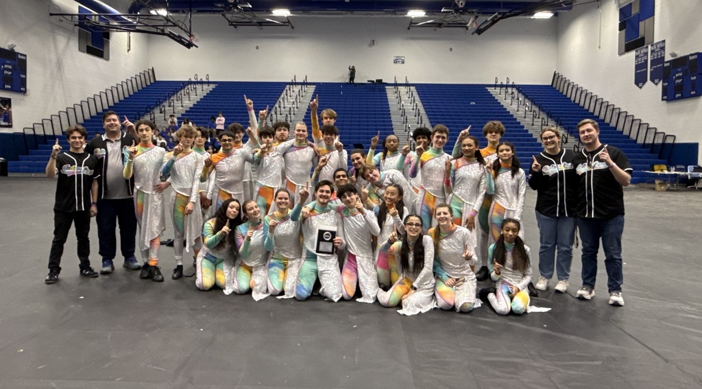 ILHS color guard poses in white costumes holding their award