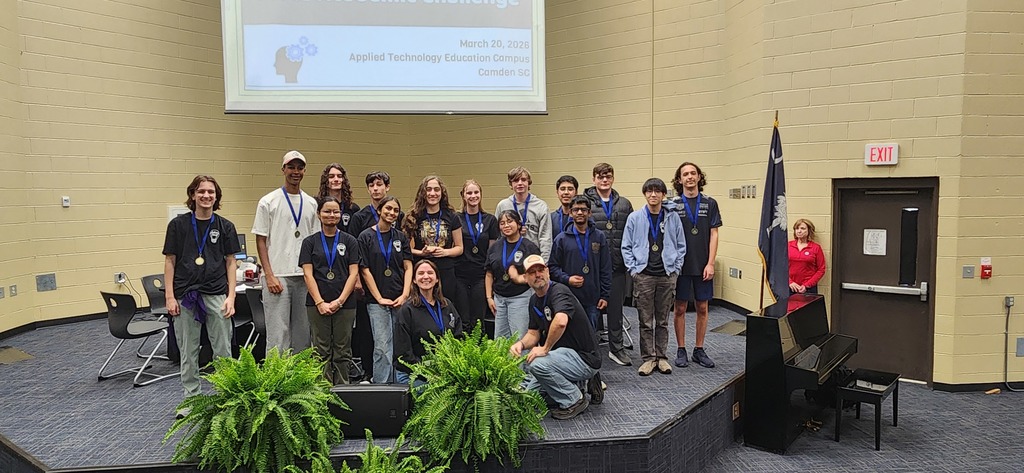 ILHS academic challenge team poses on a stage with 2nd place medals around each of their necks. 