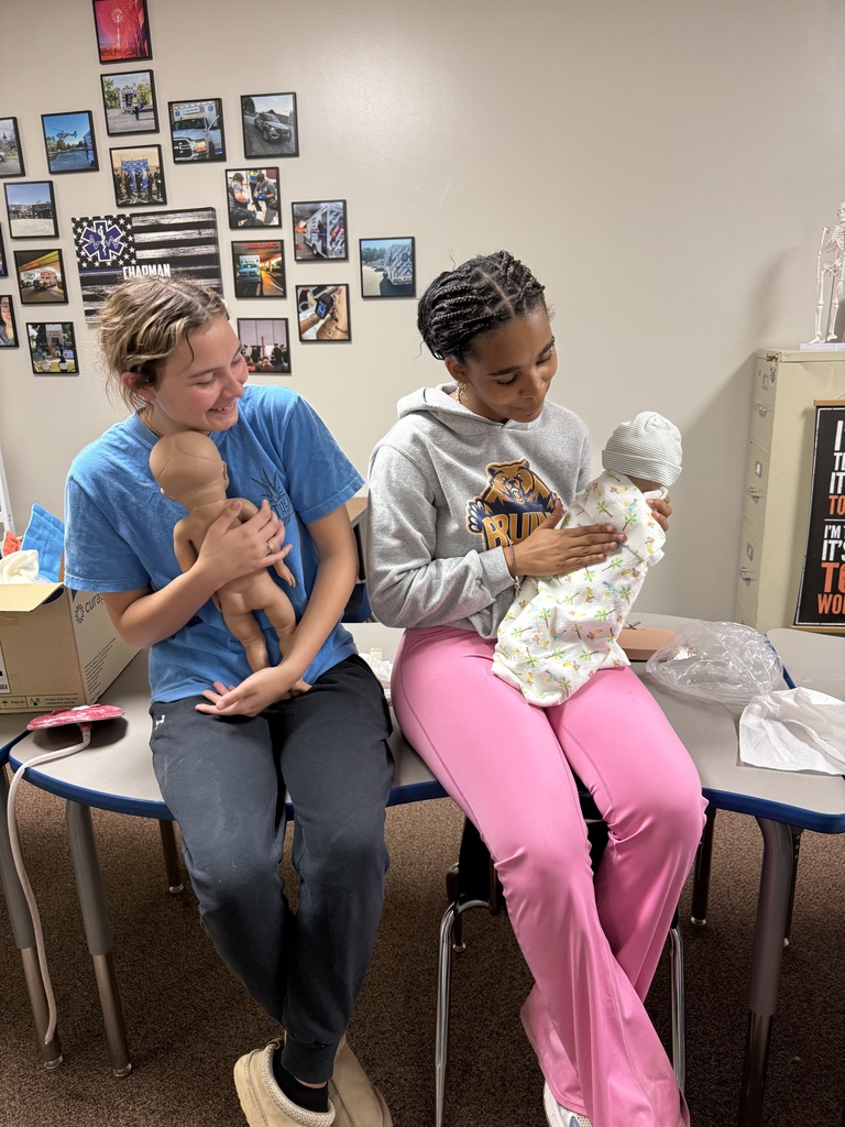 student patting back of newborn