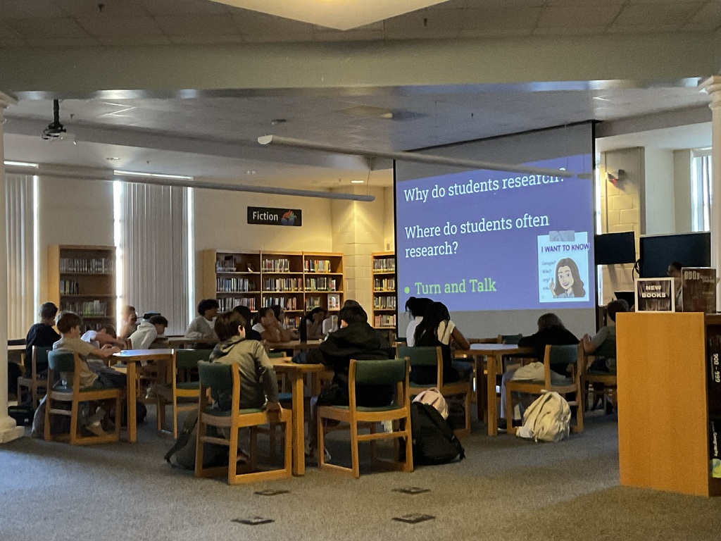 Students turned and talked with their table about research sites.