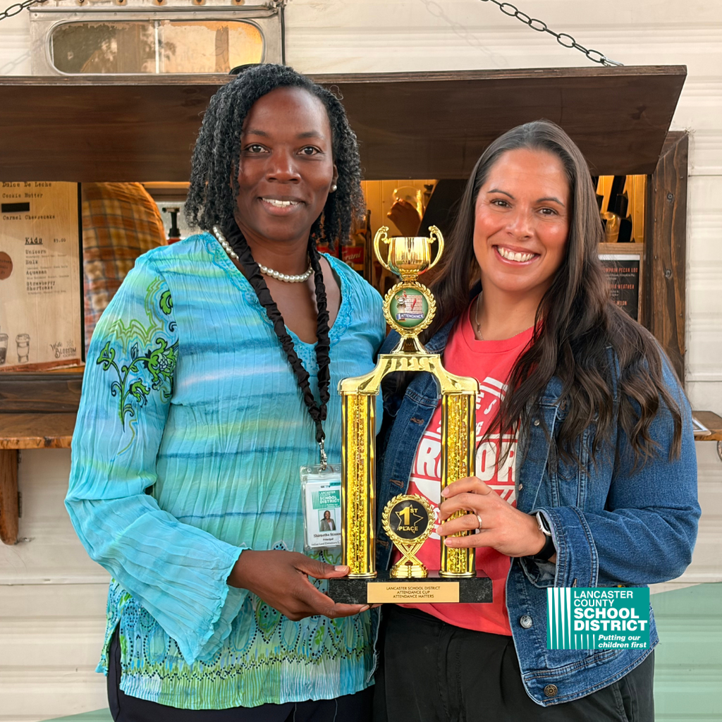 Indian Land Elementary Principal (Dr. Stinson) and Attendance Clerk (Lourdes Molina) holding Attendance Cup Trophy.